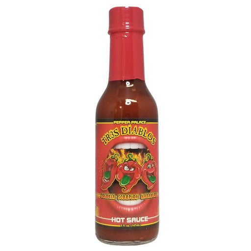 Bottle of Trs Diablos hot sauce with a red cap on a white background