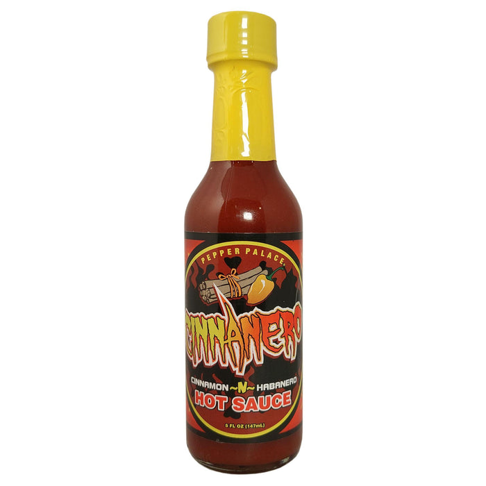 Bottle of Cinnamon Harman Hot Sauce with a yellow cap on a white background