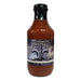 Bottle of sauce with a label on a white background