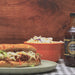 bourbon bbq being poured on a pulled pork sandwich