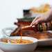 Cinnamon Habanero Hot Sauce being poured on Sweet Potatoes